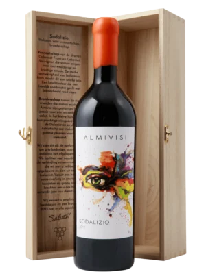 Een fles Almivisi Sodalizio rode wijn met een artistiek etiket, gepresenteerd in een houten geschenkdoos met een gegraveerd verhaal aan de binnenzijde.​