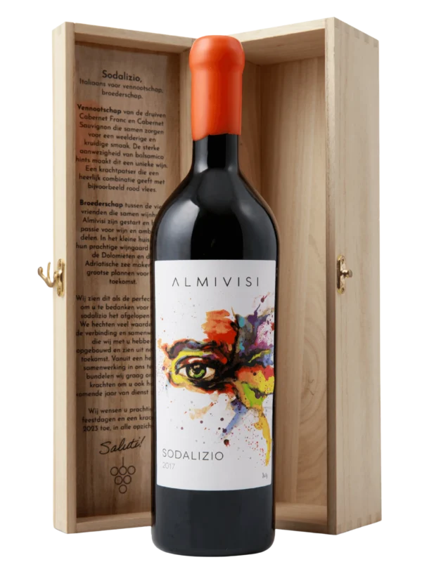 Een fles Almivisi Sodalizio rode wijn met een artistiek etiket, gepresenteerd in een houten geschenkdoos met een gegraveerd verhaal aan de binnenzijde.​